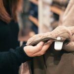 Shopper looks at a coat in a store.